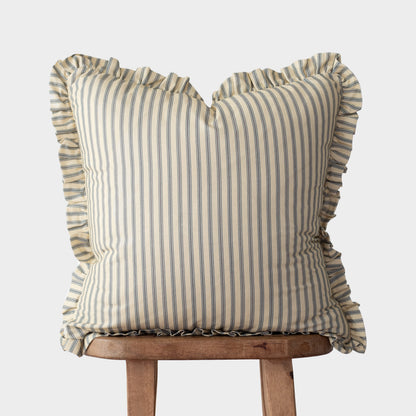 Cream and blue striped pillow with ruffled edges on all sides, displayed on a wooden stand.