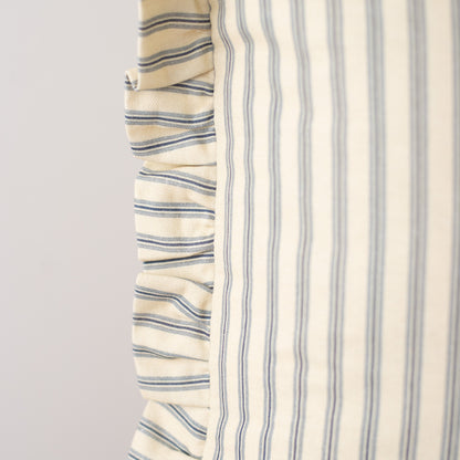 Cream pillow with navy horizontal stripes on left side and vertical stripes on right side with ruffled edge detail.