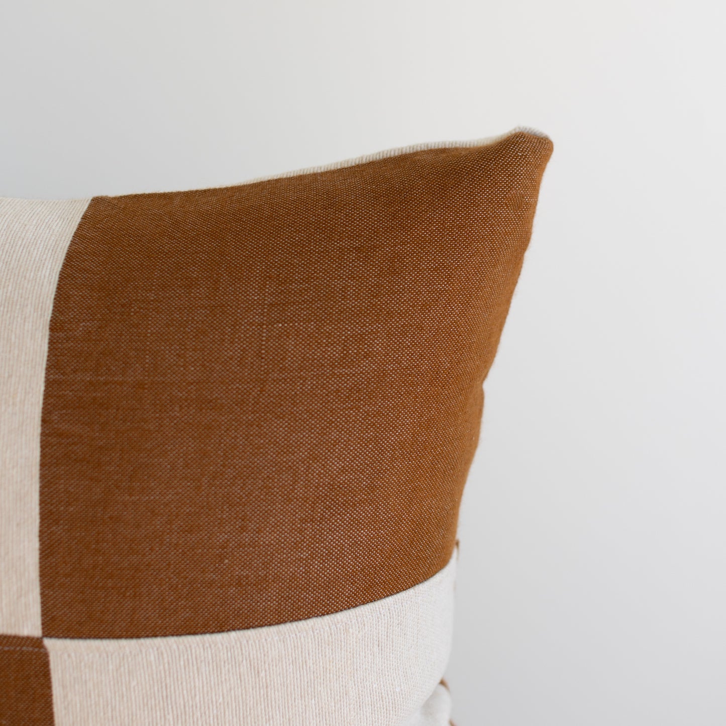Brown and cream checkered cushion cover with textured weave pattern, 22 inches.