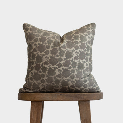 Nora pillow with gray and cream damask pattern on wooden stool.