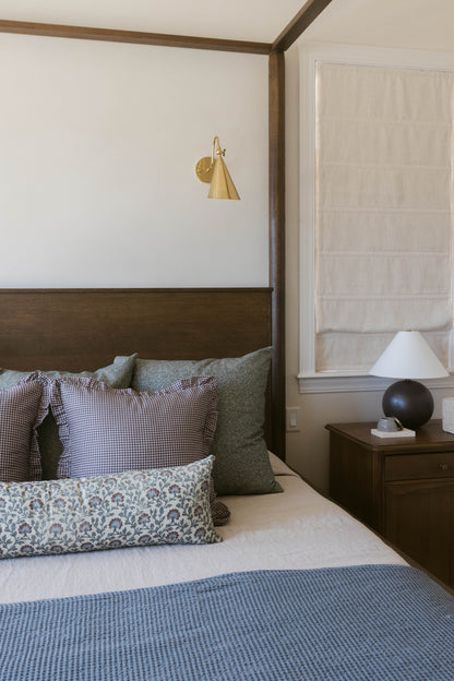 Plum mini gingham ruffle pillow with ruffled edges displayed on bed with coordinating bedding.