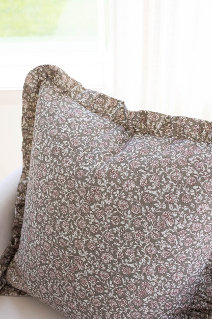 Taupe and white floral patterned pillow with ruffled edges.