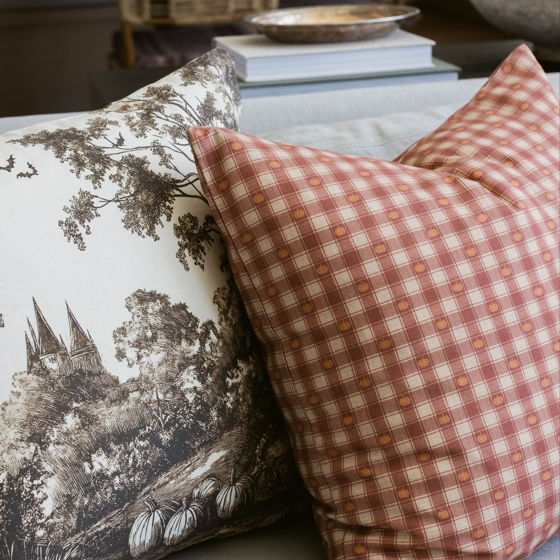 Pumpkin and cream plaid pillow with small pumpkin pattern throughout the woven fabric.