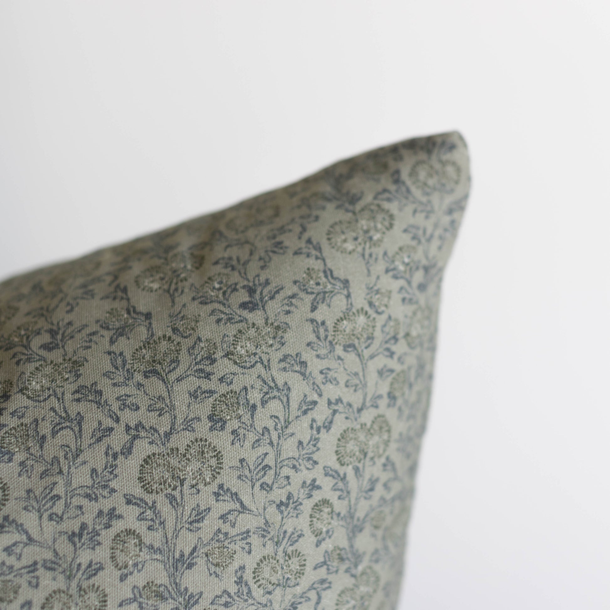 Green and blue floral patterned pillow cover with botanical print design.