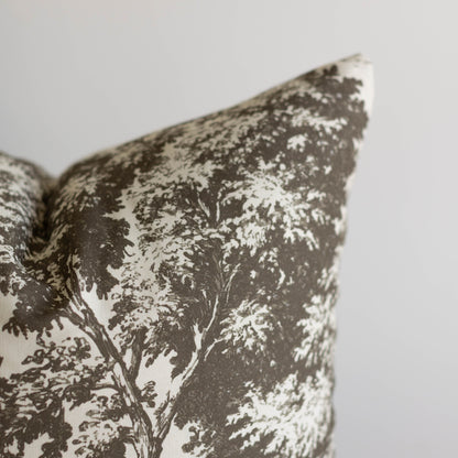 Charcoal and cream decorative pillow with tree silhouette pattern and textured weave fabric.