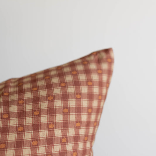 Red and cream plaid pillow with small orange pumpkin print throughout the pattern.