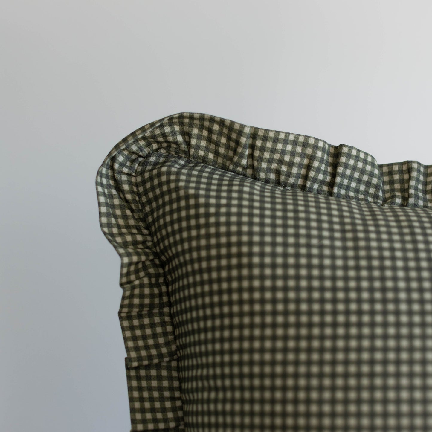 Green and white mini gingham ruffle with gathered fabric detail on light gray background.