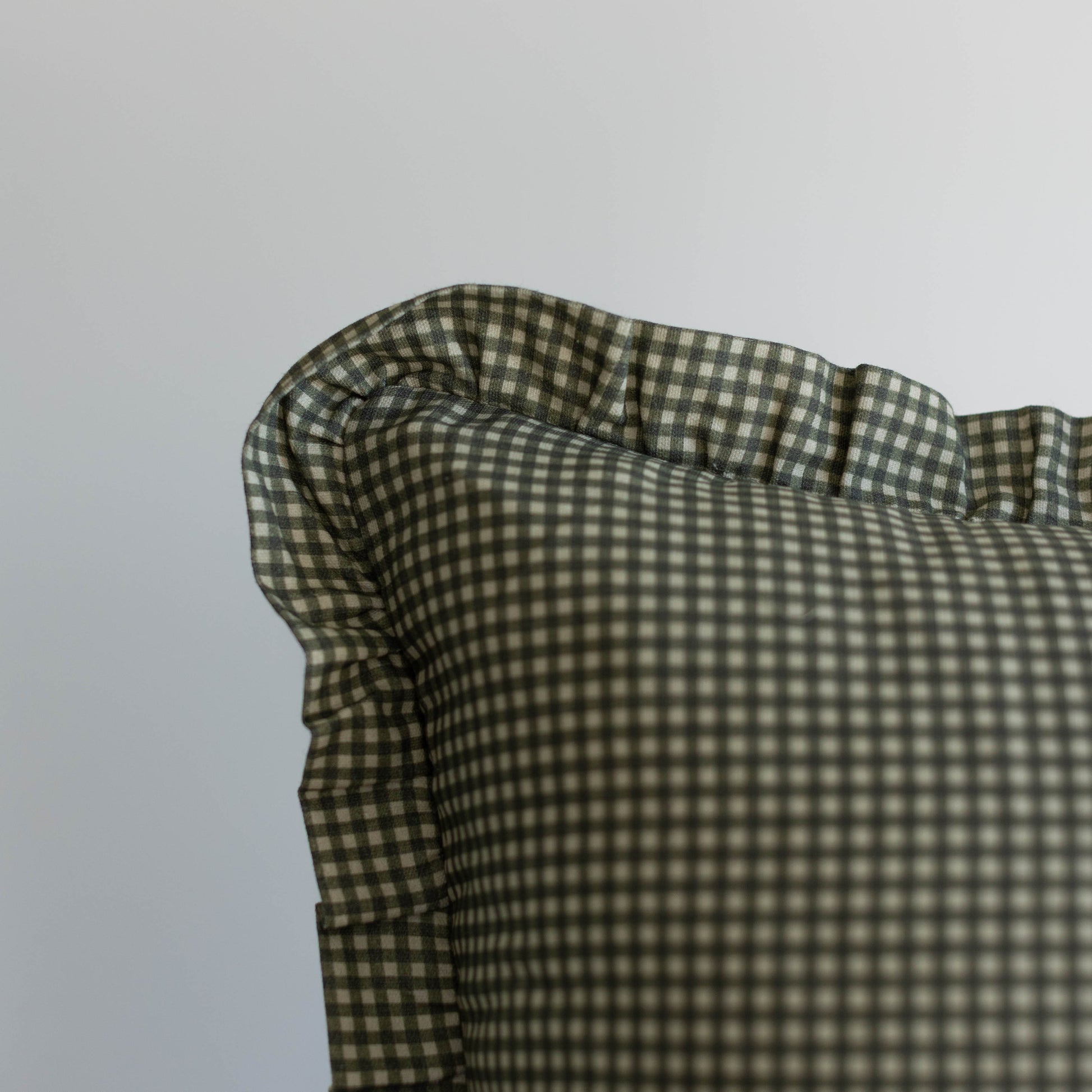 Green and white mini gingham ruffle with gathered fabric detail on light gray background.