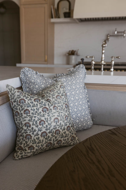 Multicolor patterned throw pillows with floral and geometric designs displayed on a kitchen sink counter.