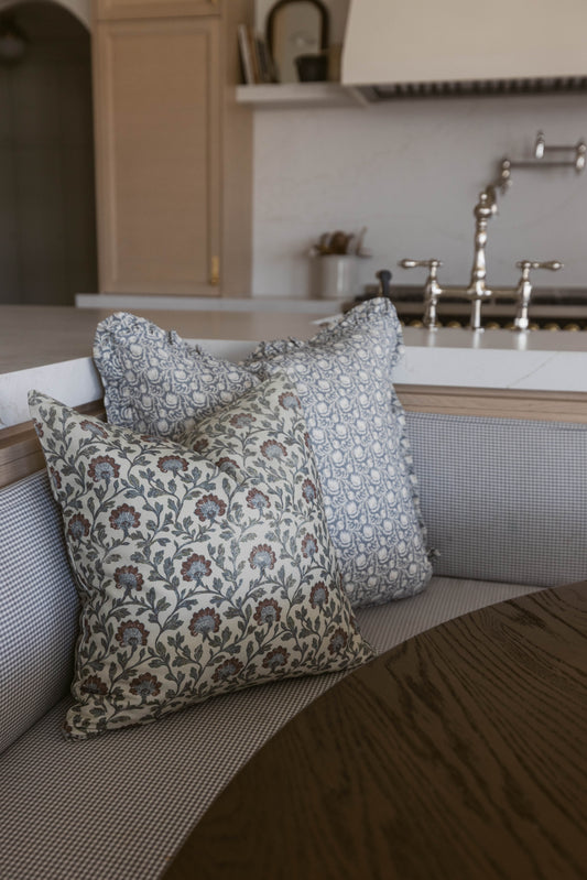Multicolor patterned throw pillows with floral and geometric designs displayed on a kitchen sink counter.