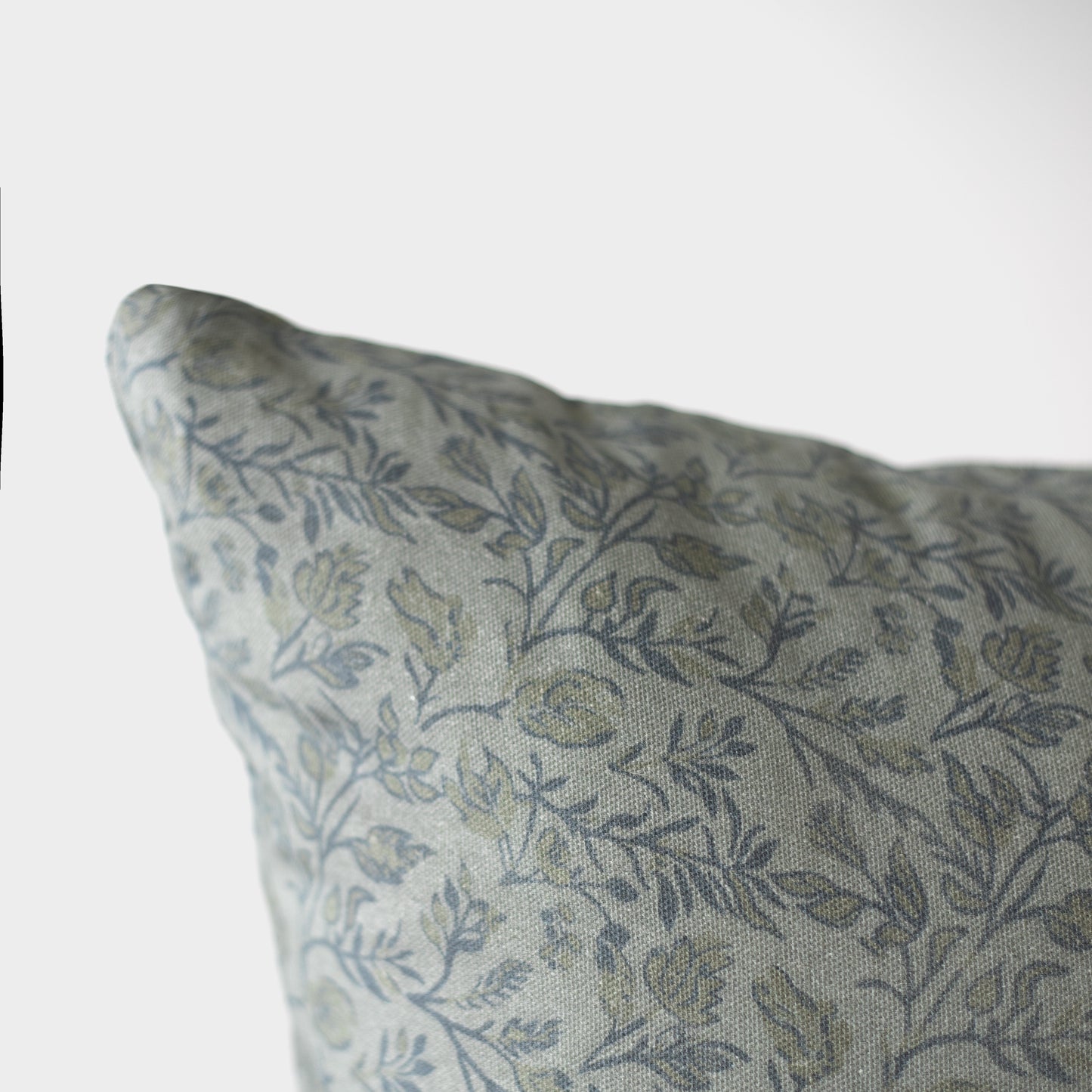 Blue and gray botanical patterned pillow cover with leaf motifs on neutral background.