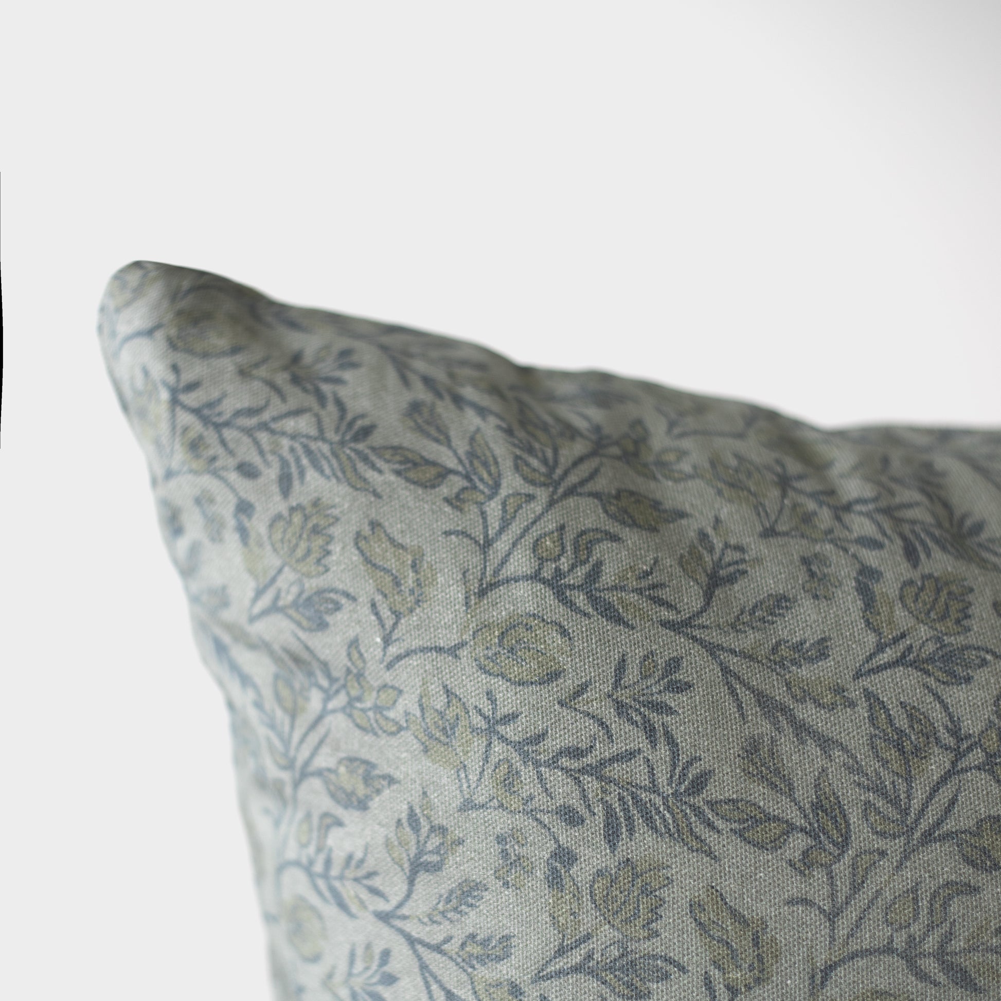 Blue and gray botanical patterned pillow cover with leaf motifs on neutral background.