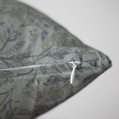 Blue and gray damask patterned pillow with white zipper closure detail.