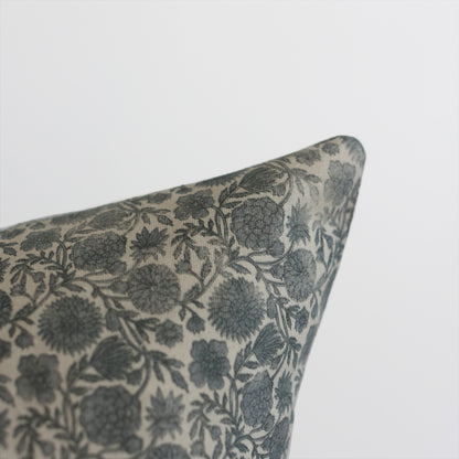 Blue and cream floral patterned pillow corner with botanical leaf design.