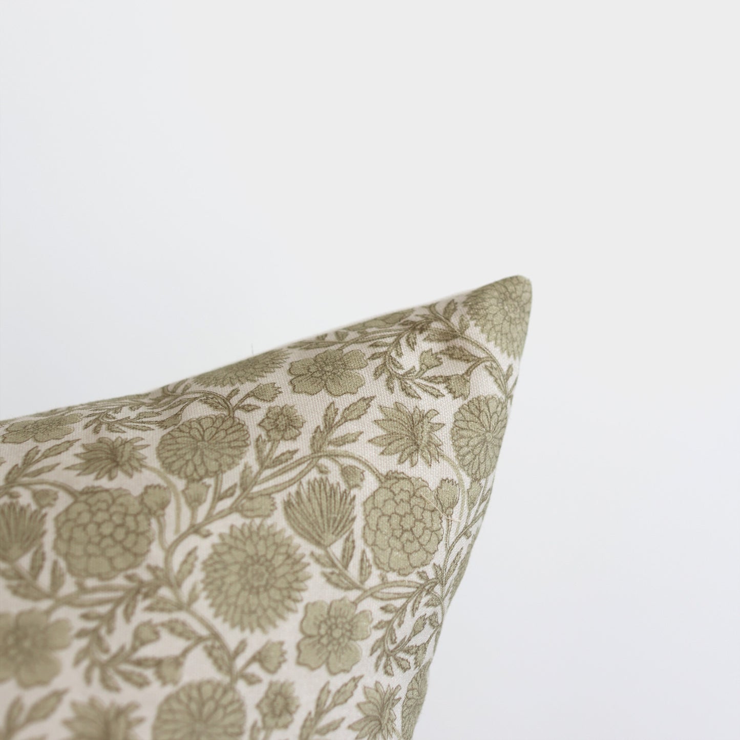 Green and cream floral patterned lumbar pillow with botanical leaf and flower design.