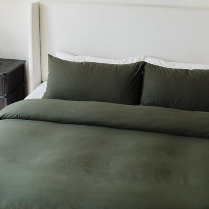 Olive-green duvet cover and two matching pillowcases on a bed with white sheets.