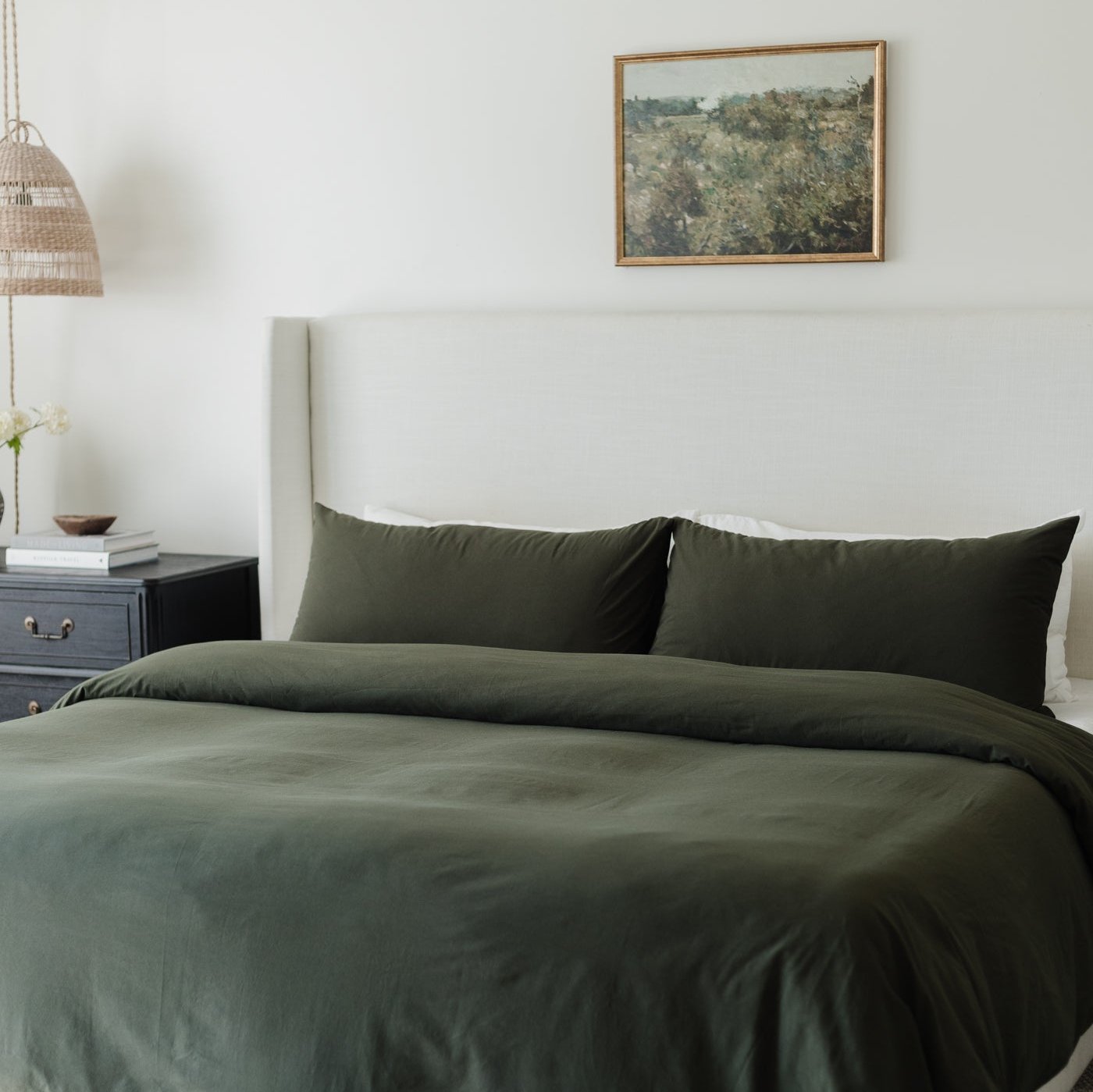 King-size bed dressed with olive-green duvet cover and matching pillowcases.