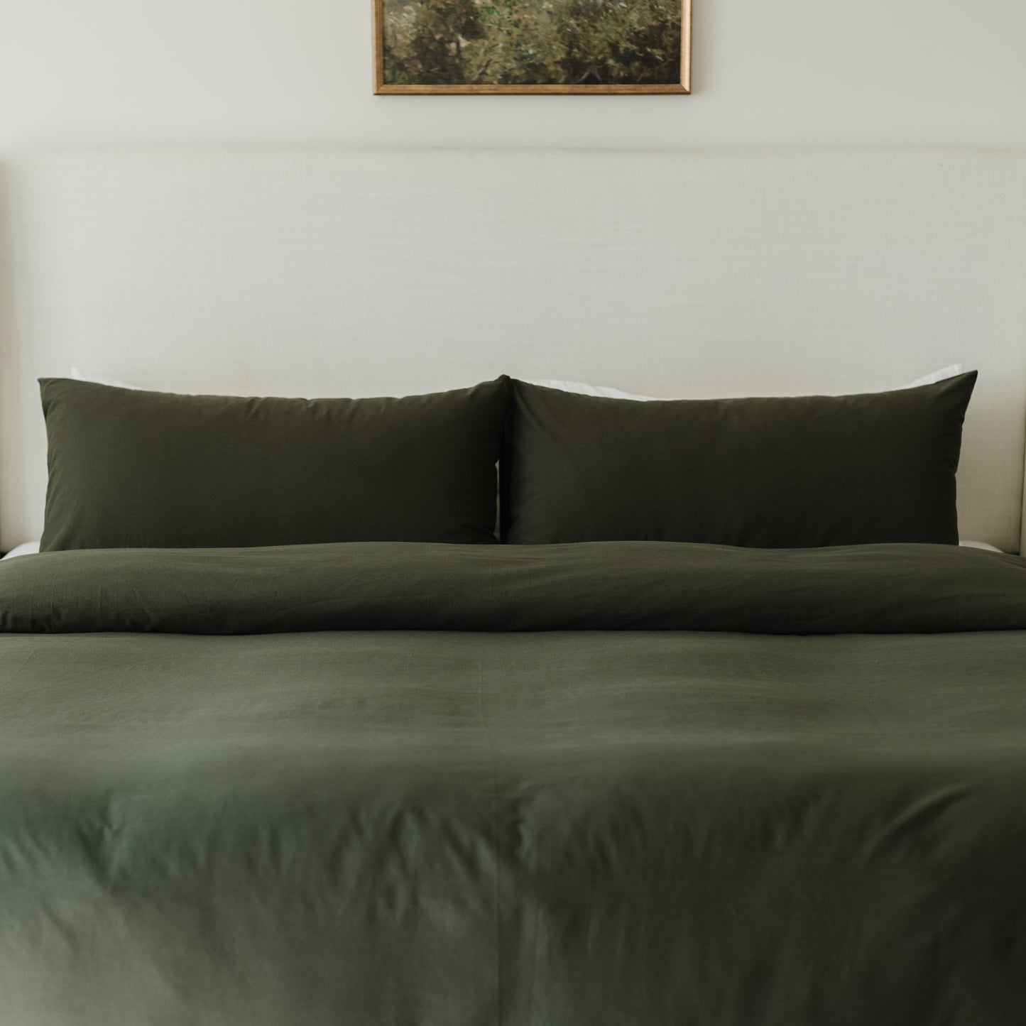 King-size bed dressed with olive-colored duvet cover and matching pillowcases.