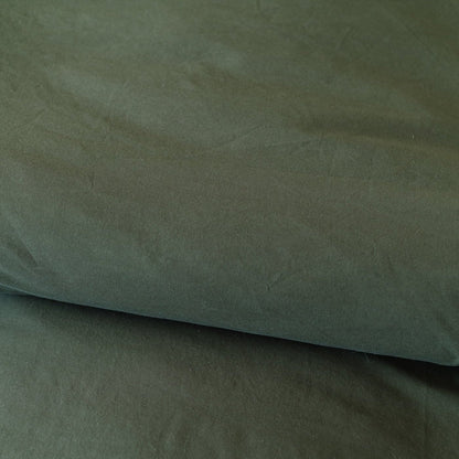 Folded olive-colored duvet cover showing the fabric texture and natural wrinkles.