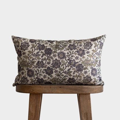 Rectangular pillow with black and gray floral pattern on cream background, displayed on wooden chair.