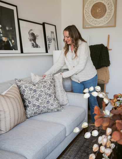 Four decorative throw pillows in varying patterns displayed on a gray sofa in a living room setting.