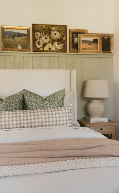 Beige and cream cotton throw blanket with thick weave texture displayed folded on a bed.