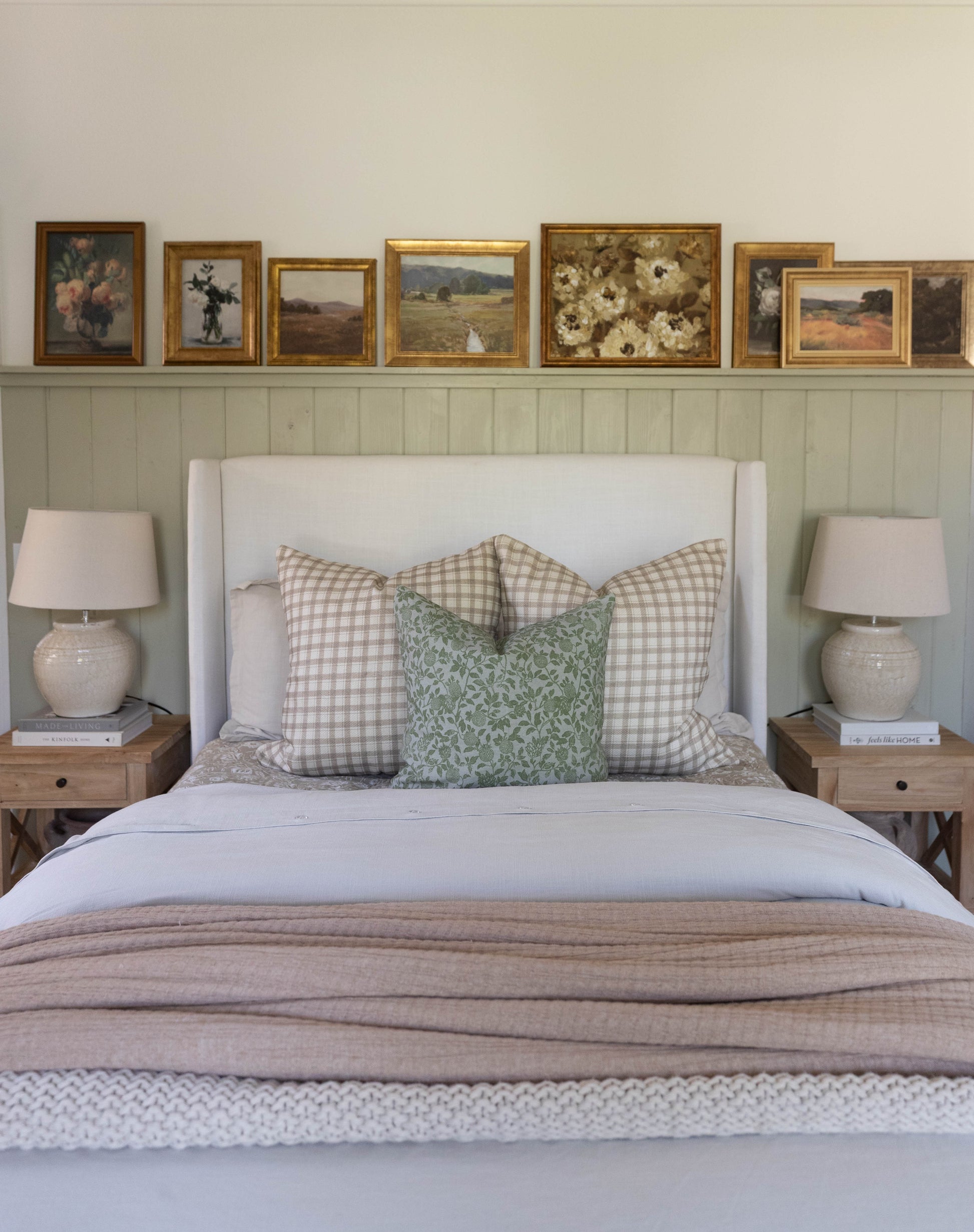 Beige and green patterned throw pillow displayed on a bed with gingham and floral cushions.