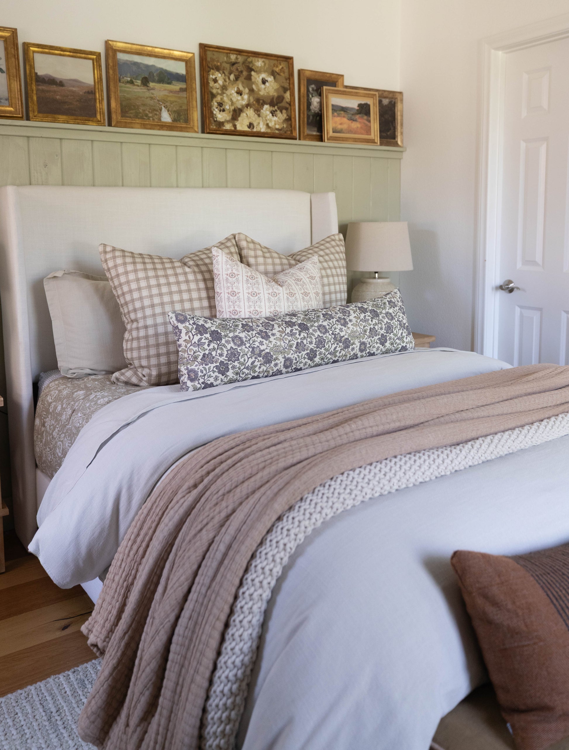Beige and cream thick weave cotton throw draped across a made bed with patterned pillows.