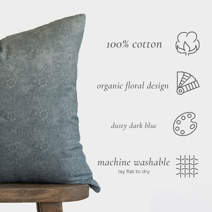 Dusty dark blue cotton pillow with organic floral design, displayed on wooden stool.