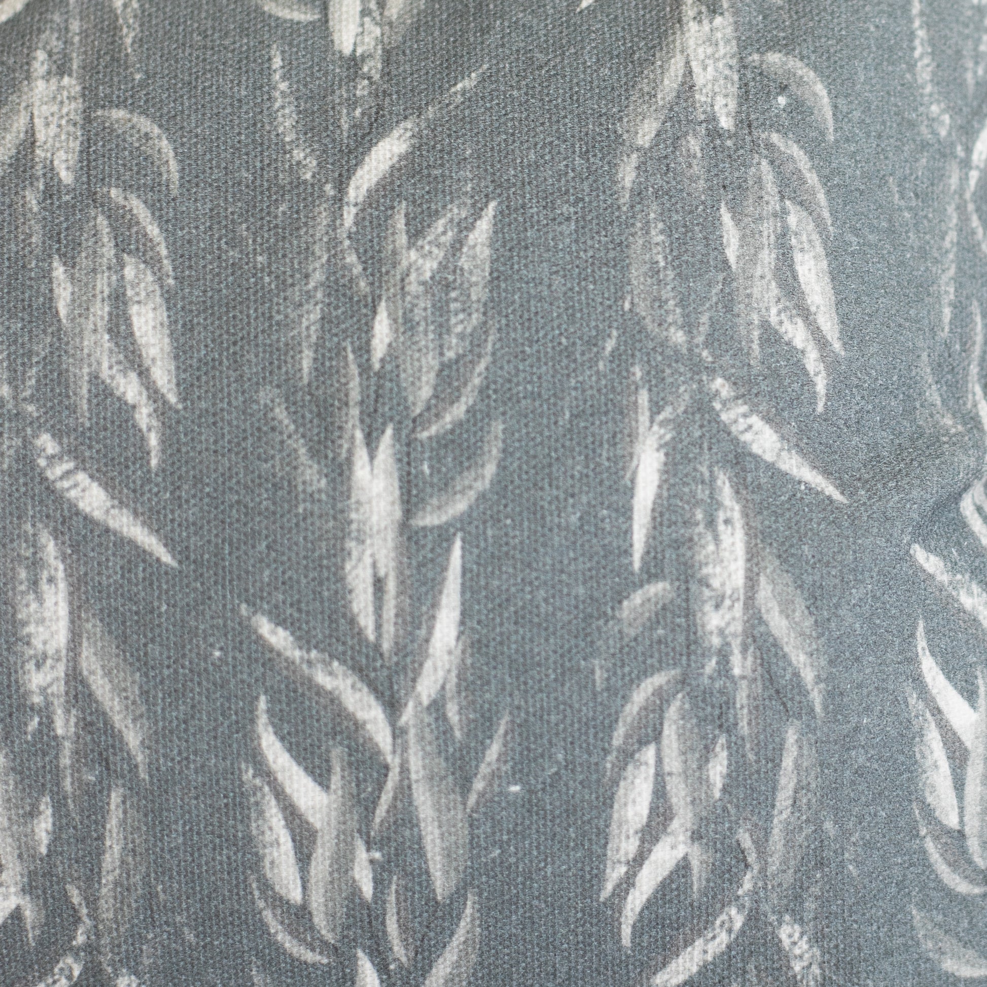 Gray lumbar pillow with white sage leaf pattern on textured fabric.