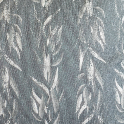 Gray lumbar pillow with white sage leaf pattern on textured fabric.