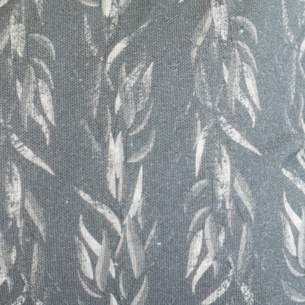 Gray lumbar pillow with white sage leaf pattern on textured fabric.