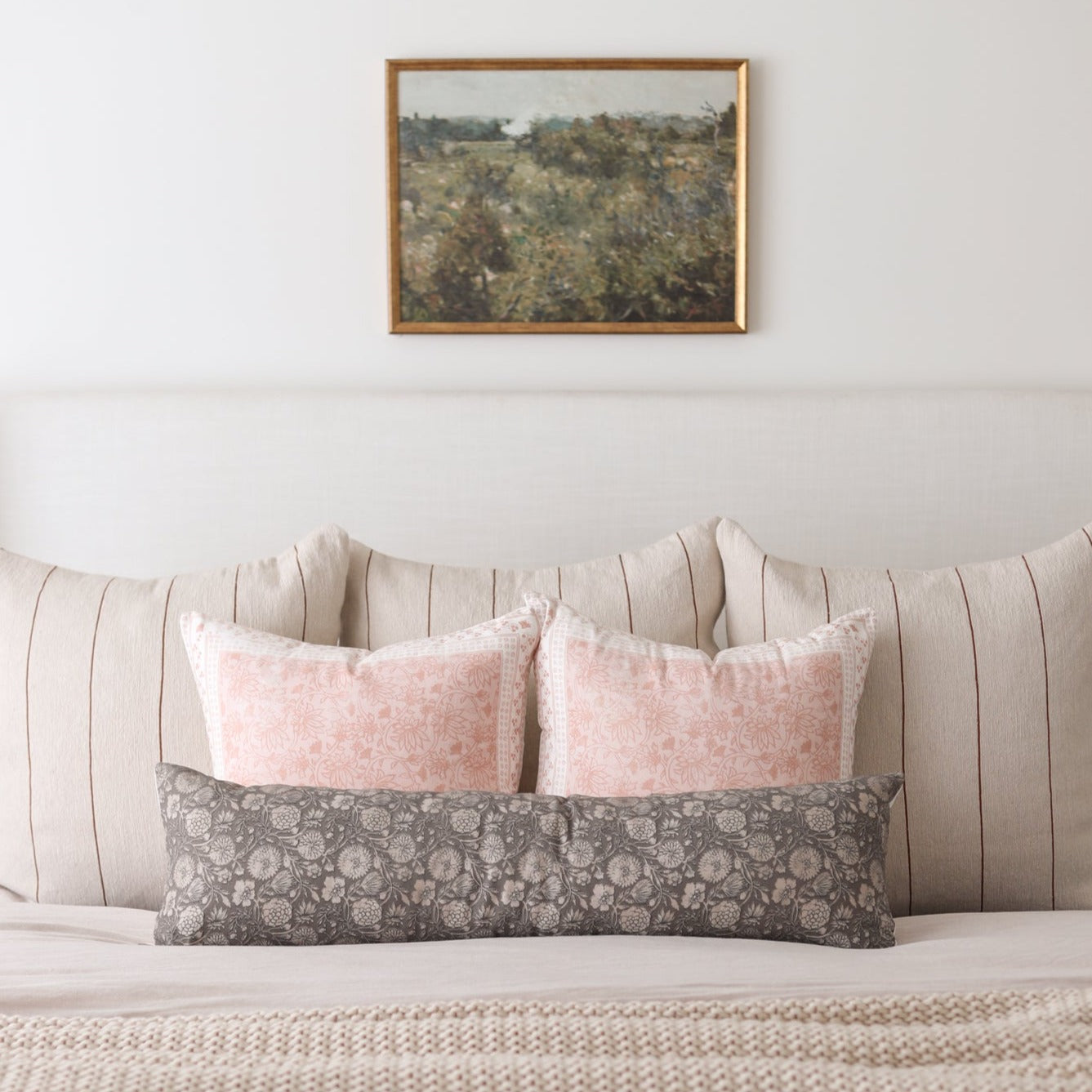Framed landscape artwork with gold-toned border depicting a scenic hillside with trees and sky.