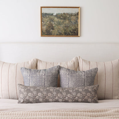 Rectangular lumbar pillow with taupe diamond floral pattern on a thick woven fabric, displayed on a bed.