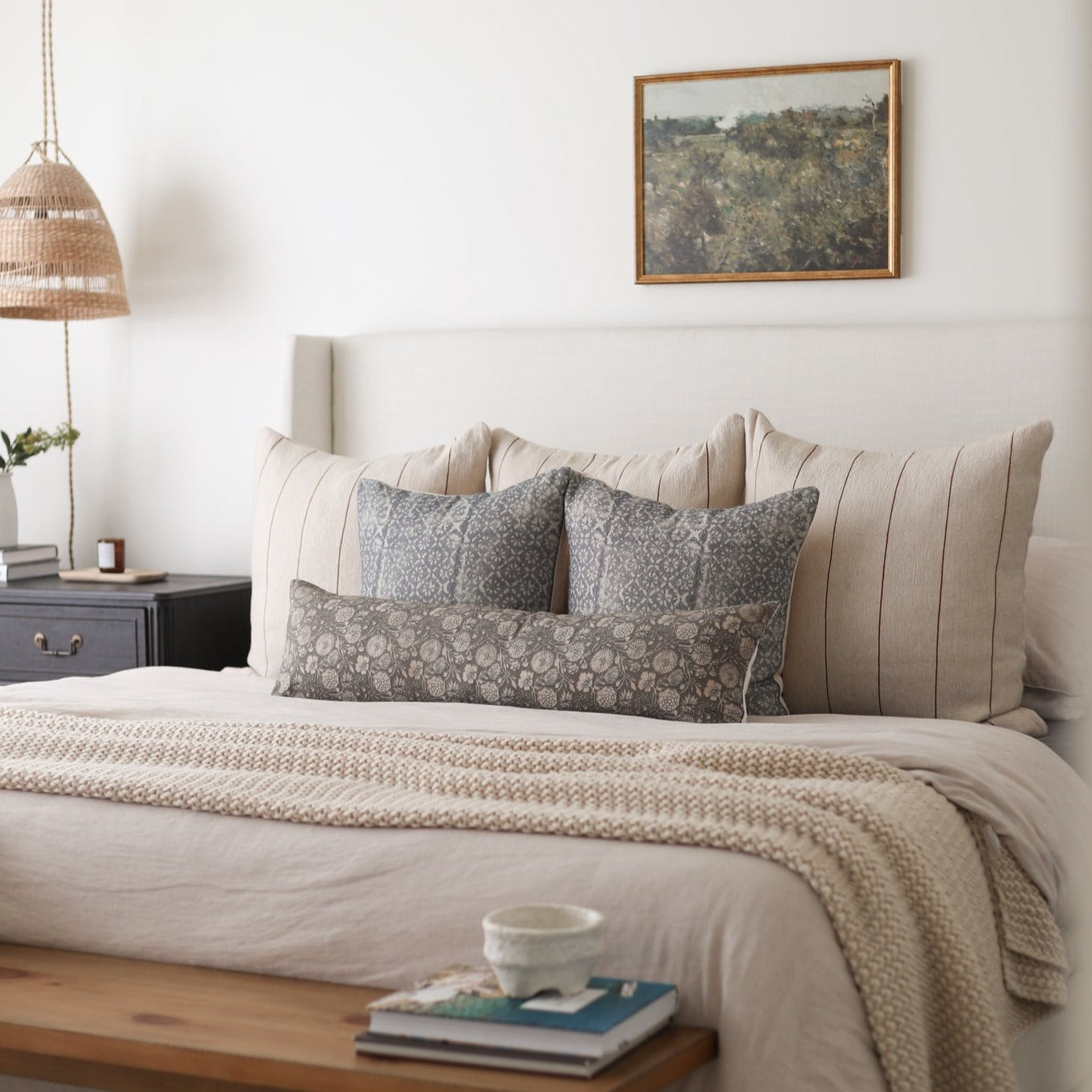 Gray patterned lumbar pillow displayed on a bed with coordinating pillows and neutral bedding.