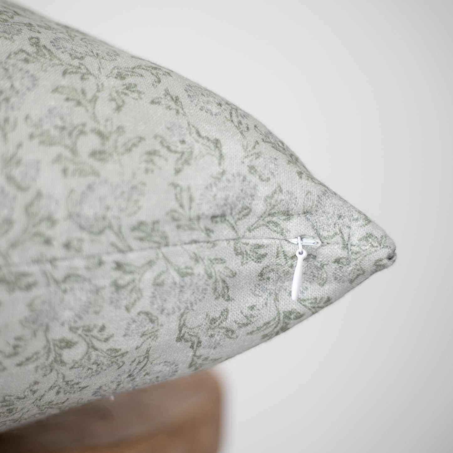 Cream linen pillow with gray damask pattern and white zipper closure.