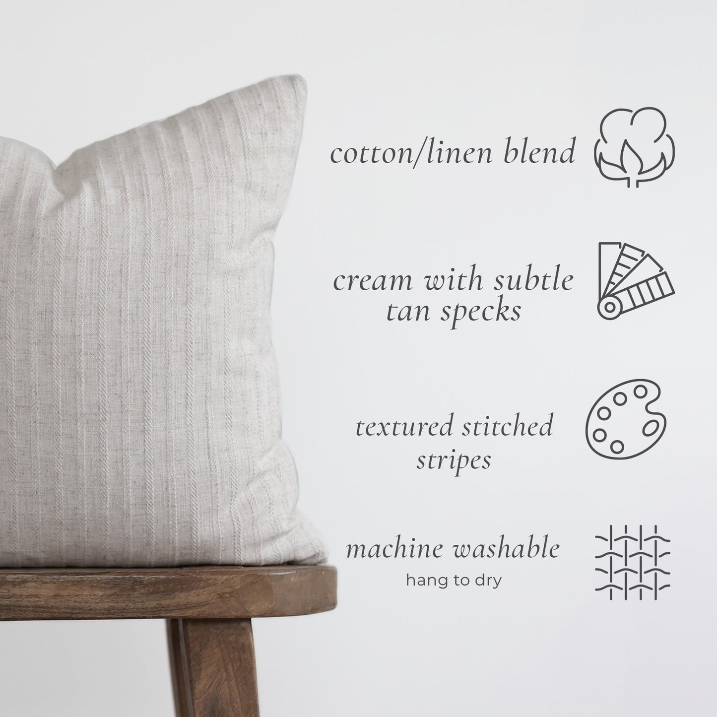 Cream cotton linen pillow with textured stitched stripes on wooden stool.