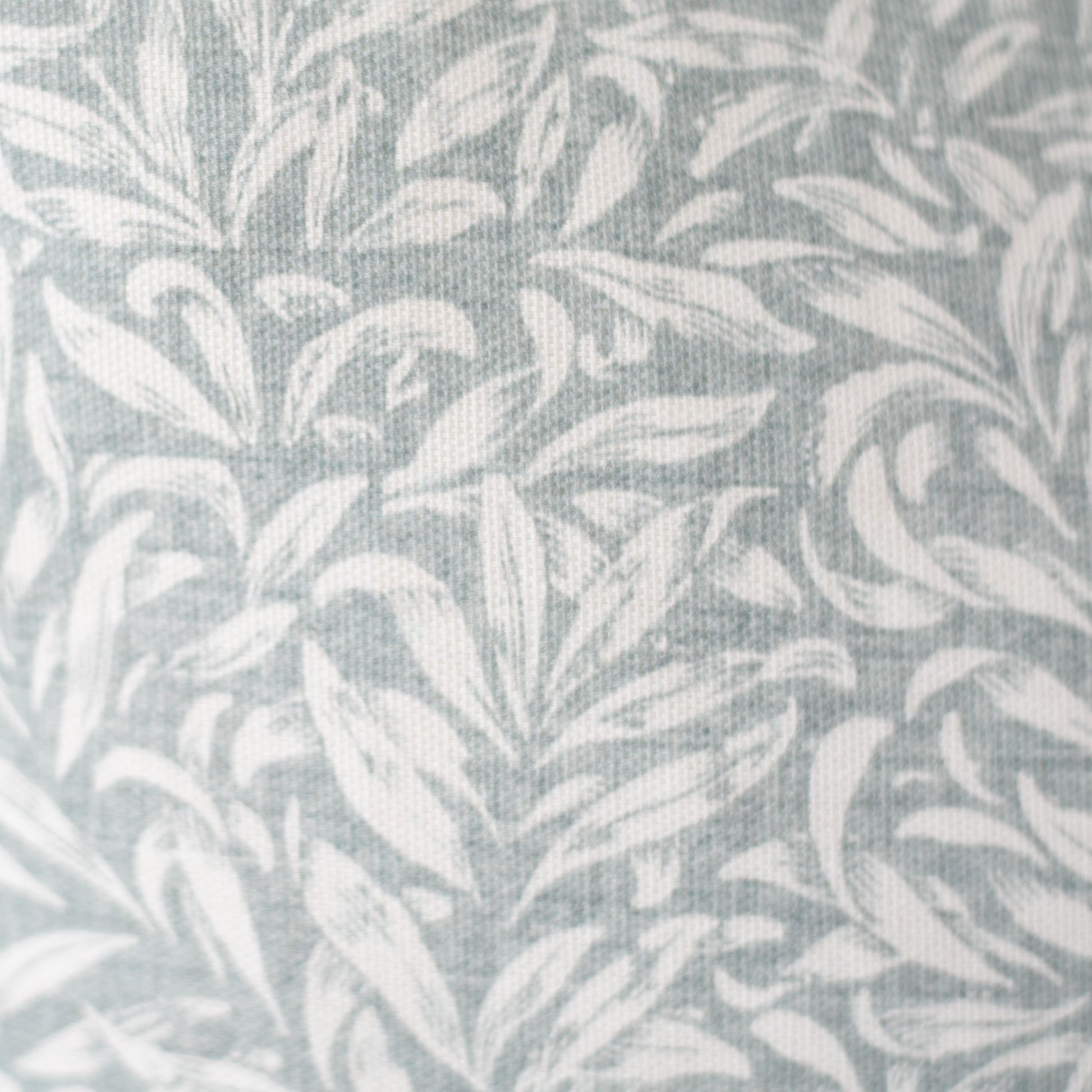 Gray and white textile with repeating leaf pattern and woven texture.
