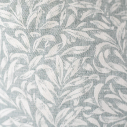Gray and white textile with repeating leaf pattern and woven texture.
