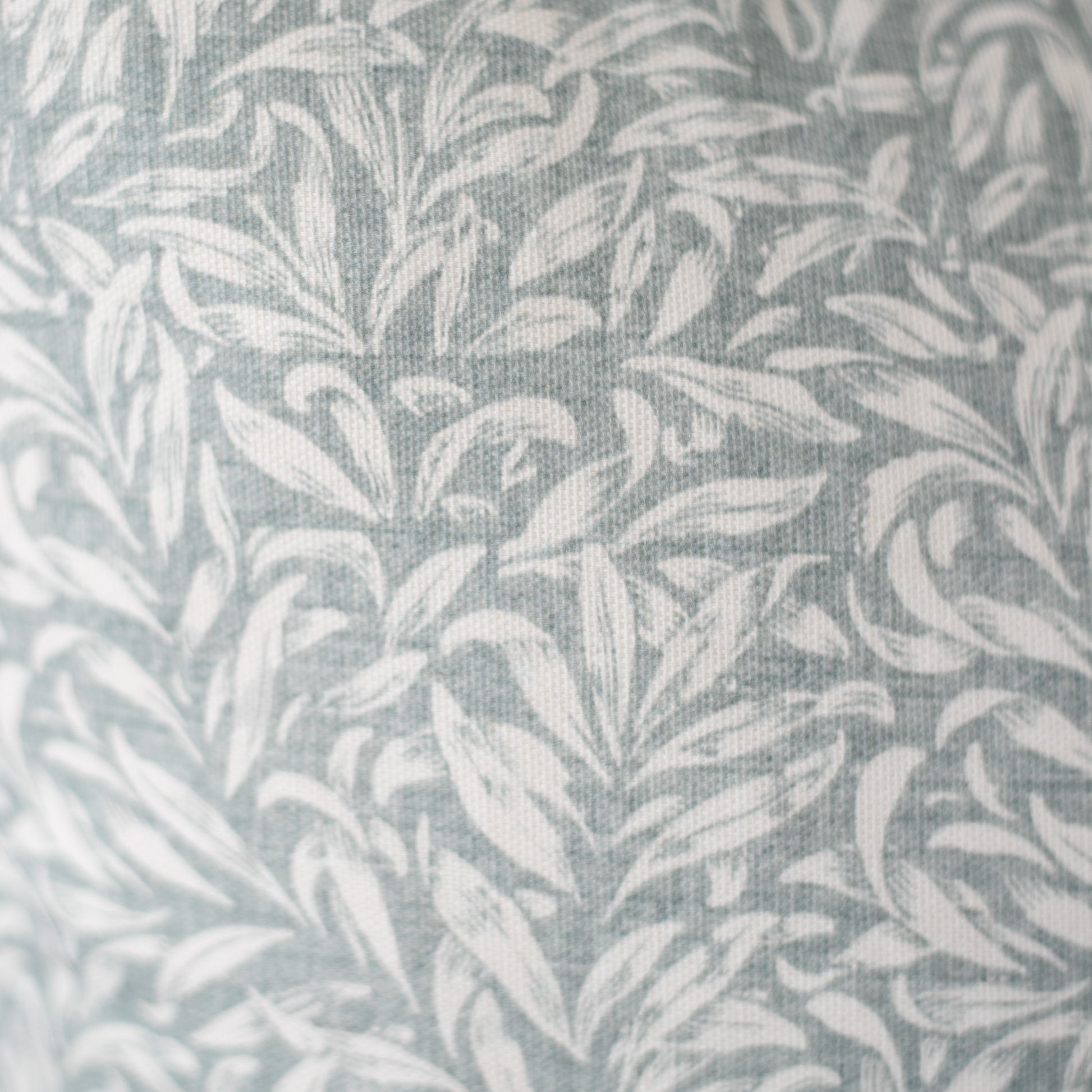 Gray and white leafy damask pattern on woven textile fabric.