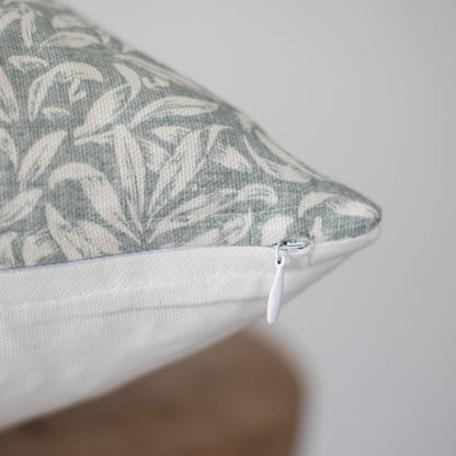 Rectangular pillow with gray and cream botanical leaf pattern and white zipper closure.