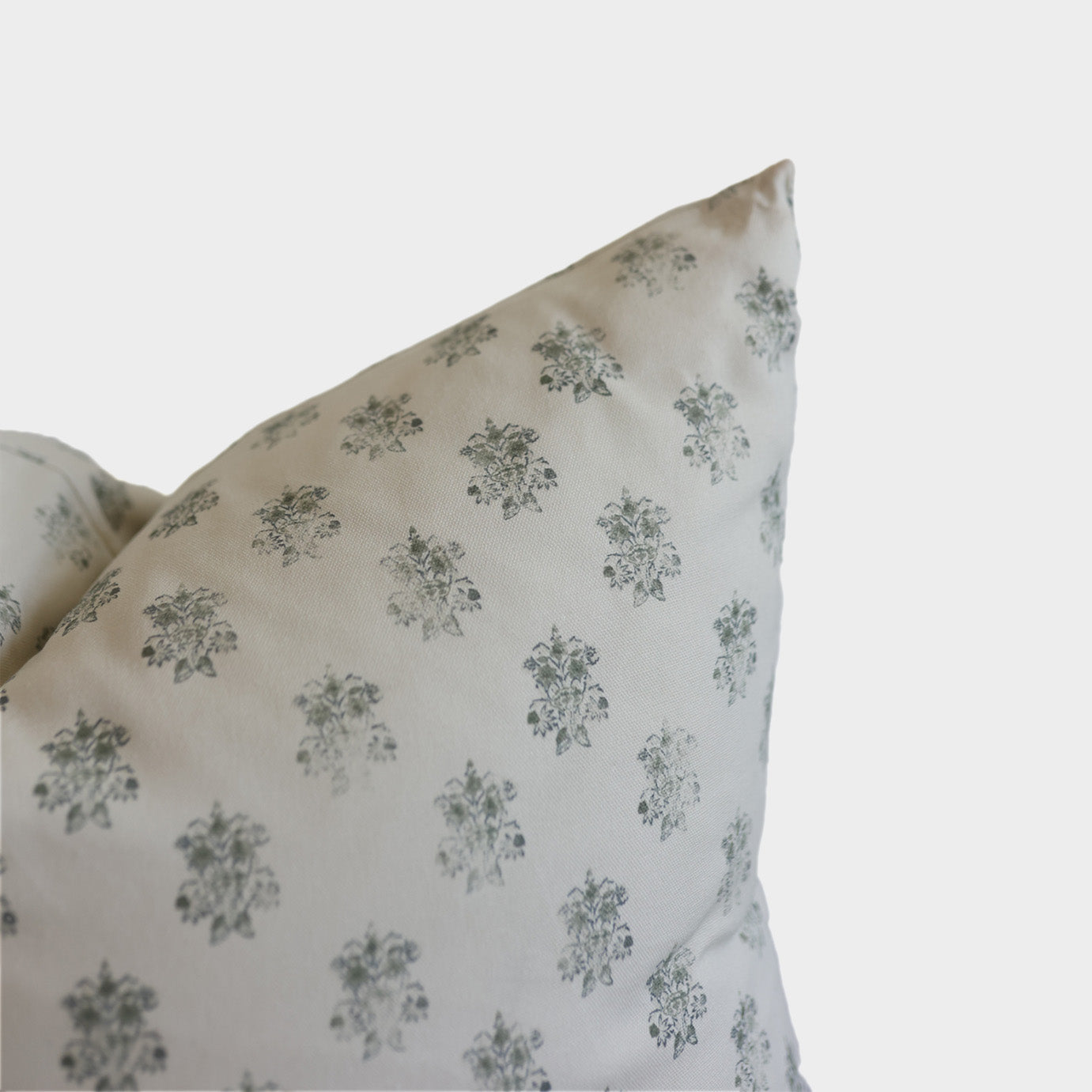 Blue pillow with repeating gray floral damask pattern on white background.