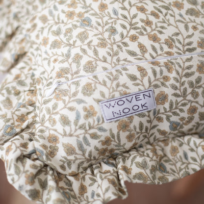 Cream-colored fabric with tan and gray floral leaf pattern and ruffled edge detail.