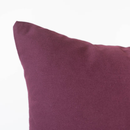 Merlot-colored pillow with textured fabric and a soft, filled form.