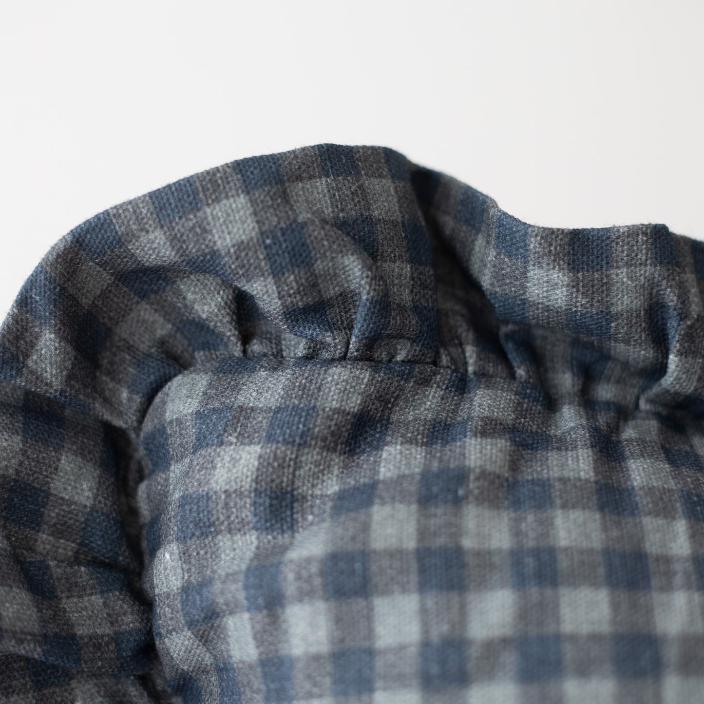 Navy and white gingham check pillow with ruffled edge detail.