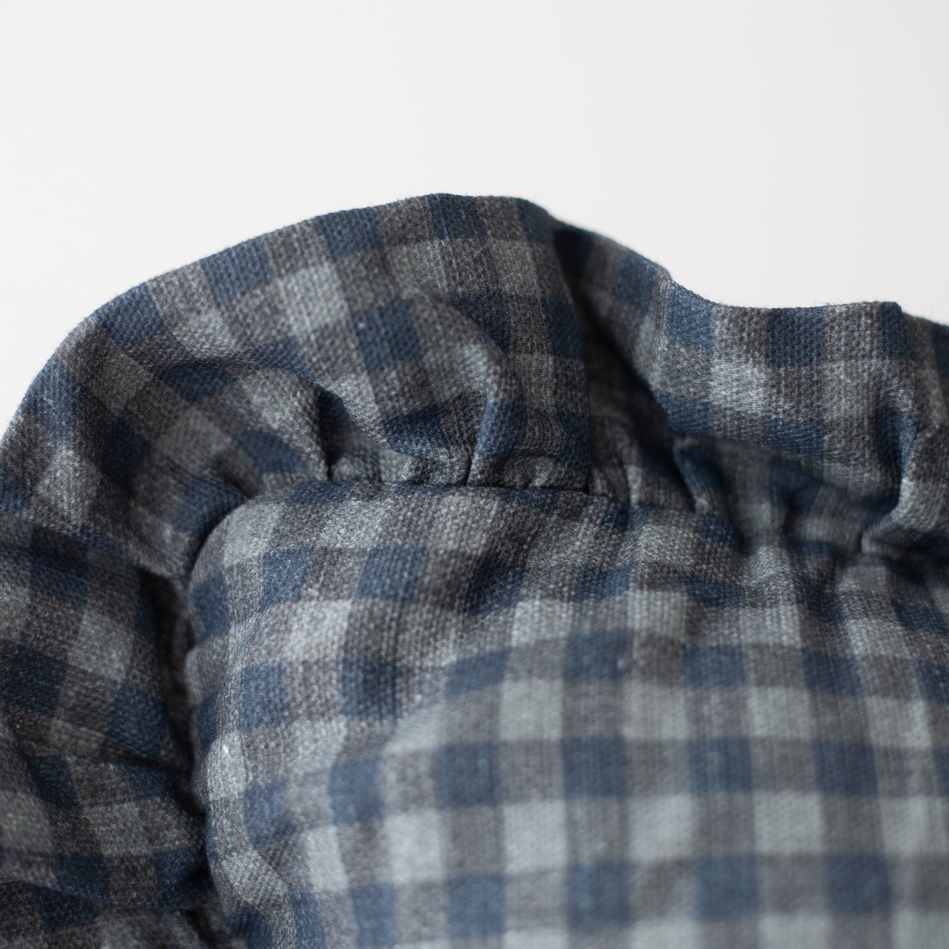 Navy and white gingham check pillow with ruffled edge detail.
