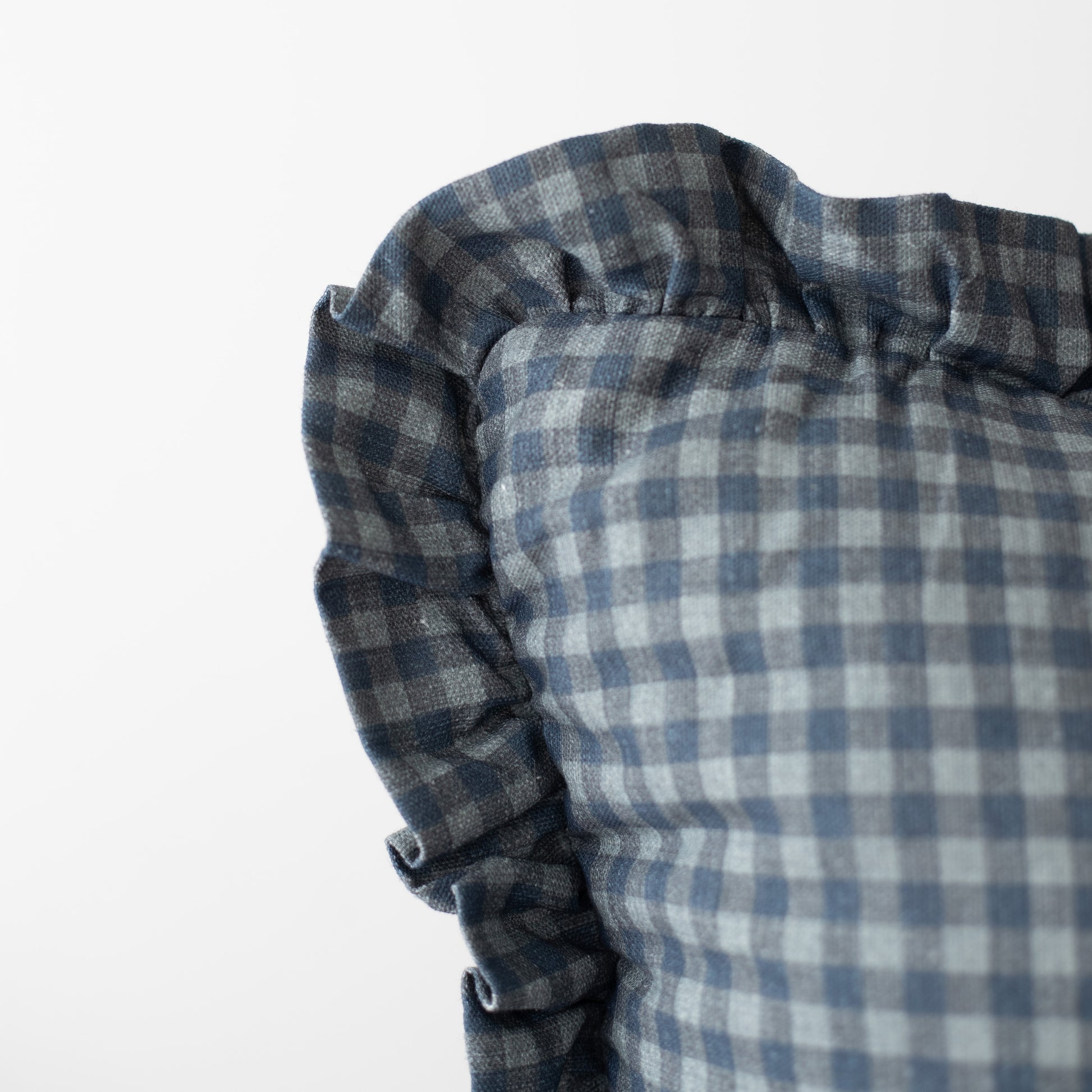Navy gingham pillowcase with ruffled edges in blue and white checked pattern.