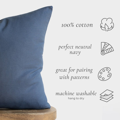 Navy blue cotton pillow cover displayed on wooden base with product details listed.