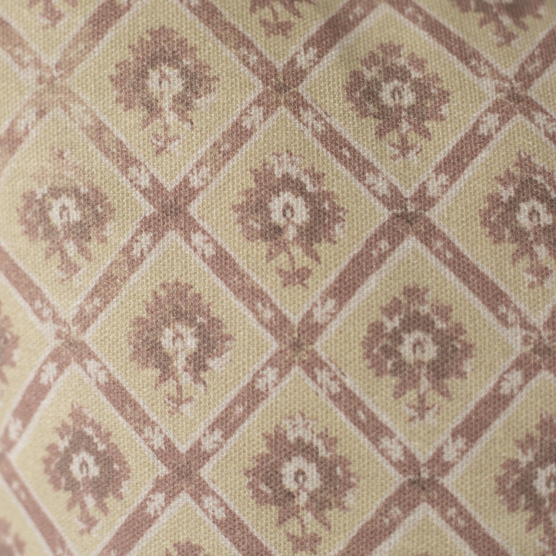 Beige and mauve textile with geometric diamond pattern containing floral motifs in a woven weave.