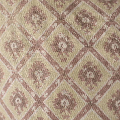 Beige and mauve textile with geometric diamond pattern containing floral motifs in a woven weave.